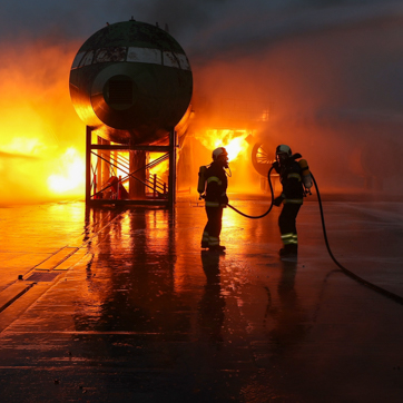 siluetter af brandmænd foran flammer