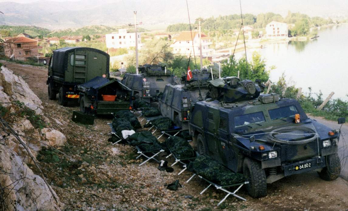 Soldater fra 1. Lette Opklarinseskadron i Albanien hviler på feltsenge ved siden af deres Eagle 1 køretøjer. .