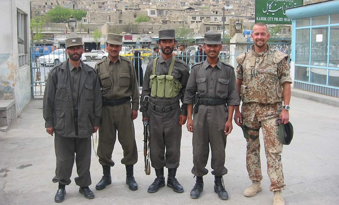 Dansk forbindelsesofficer står sammen med afghanske politifolk i hovedkvarteret for Kabul City Police i 2004.
