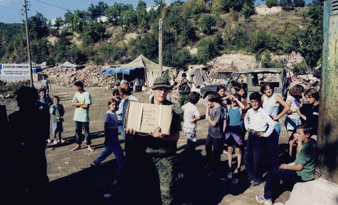 Danske soldater uddeler nødhjælp i flygtningelejr for romaer i Cabra.Foto taget i forbindelse med H.K.H. Prins Hernik (prinsgemalens) besøg ved de danske styrker ved missionen Kosovo Force (KFOR). Besøget fandt sted 22-24. september 1999 samme år som KFOR-styrken landede i missionsområdet.