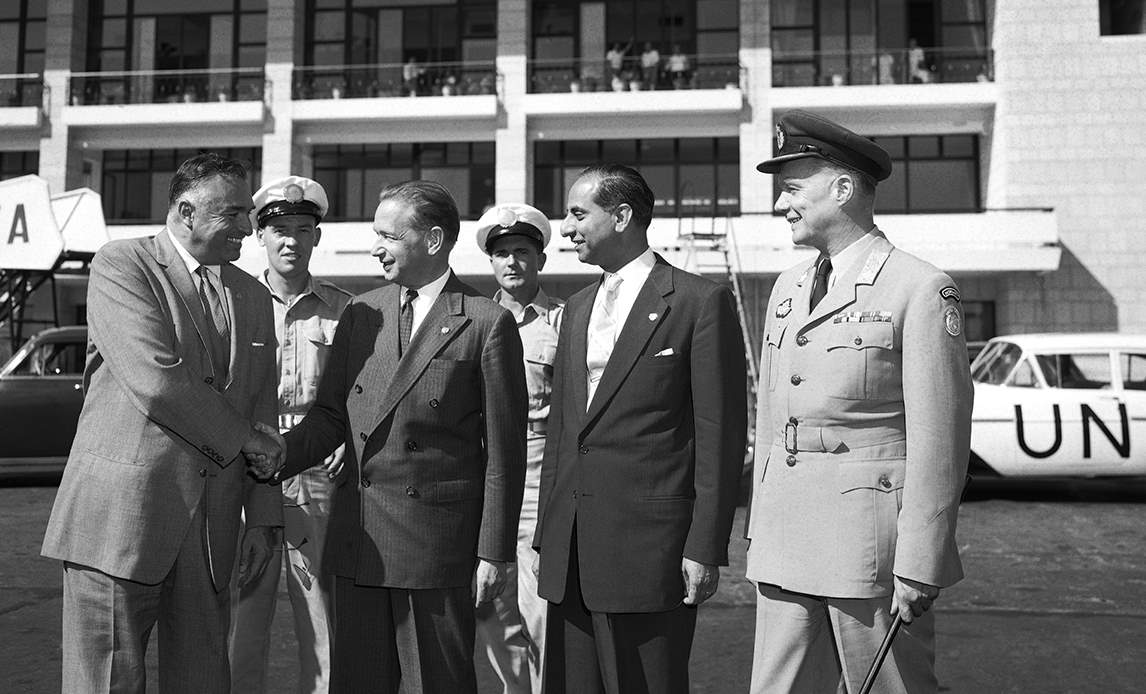 FNs generalsekretær Dag Hammerskjöld (nummer to fra venstre) tager afsked 12. september 1958 afsked med FN-missionens militære chef, den norske generalmajor Odd Bull. I baggrunden står der flere af officererne ved UNOGIL. UN Photo.
