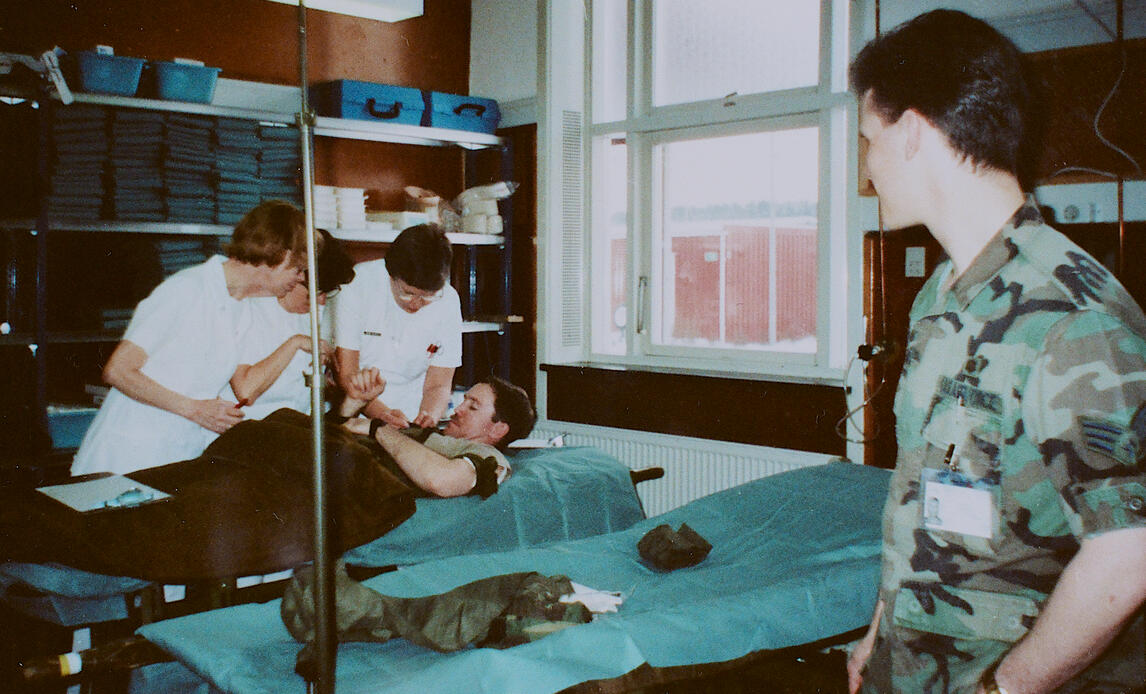 Billedet er fra opbygningen af Holstebro Militærhospital (HMH), som blev etableret på Dragon Kasernen i Holstebro, som et dansk bidrag til den 1. Golfkrig 1990-91. På kasernen lå amerikansk materiel til et såkaldt Contingency Hospital.


Dansk sygeplejepersonale træner med figurant i forbindelse med opbygningen af Holstebro Militærhospital (HMH), som var etableret på Dragon Kasernen i Holstebro i perioden JAN-MAR 1991, som et dansk bidrag til 1. Golfkrig. En sergent fra det amerikanske flyvevåben ser til. Der indgik et lille amerikansk forbindelseselement til HMH.