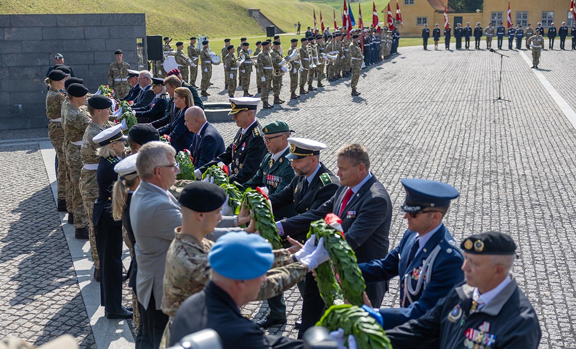 Repræsentanter fra Folketinget, regeringen, udsendende myndigheder, fagforeninger, veteranorganisationer, udenlandske samarbejdspartnere med flere lægger kranse i Kastellet på flagdagen i 2024. Foto: Simon Elbeck / Forsvaret