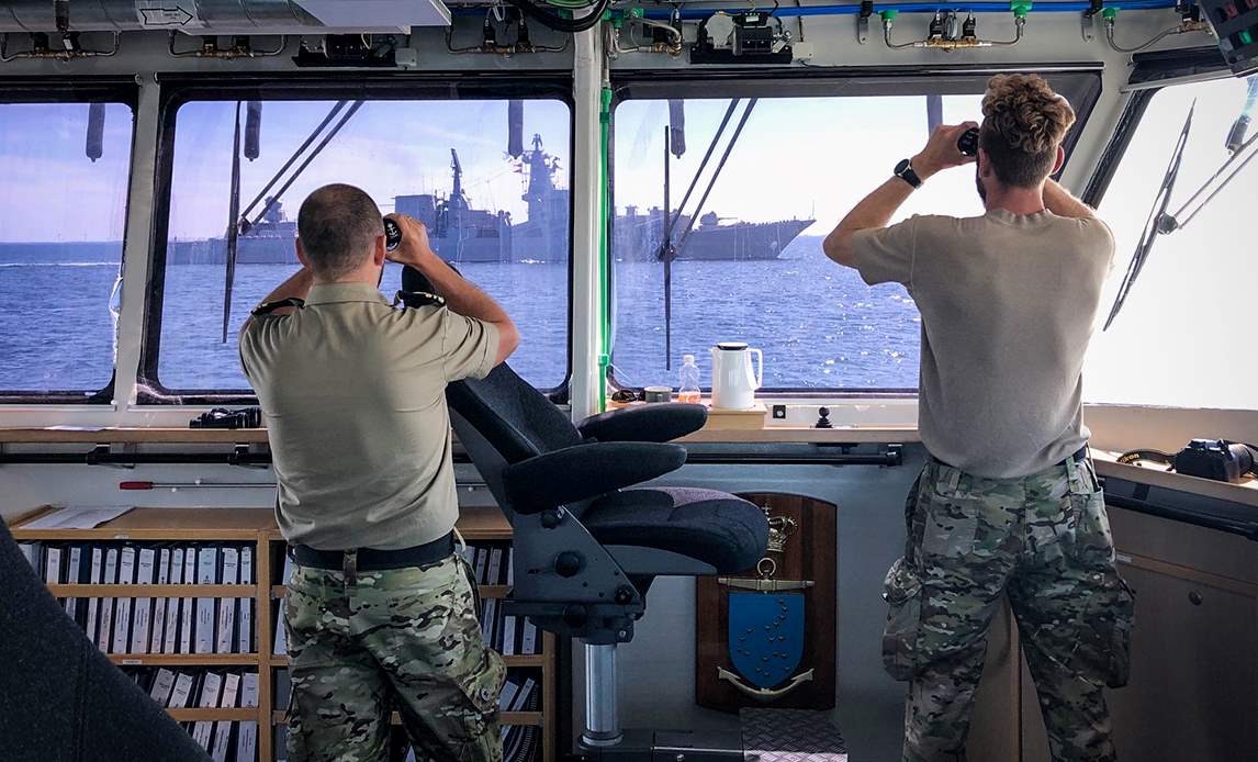 Besætningsmedlemmer fra patruljefartøjet Nymfen holder øje med et russisk krigsskib, der er på vej gennem dansk farvand