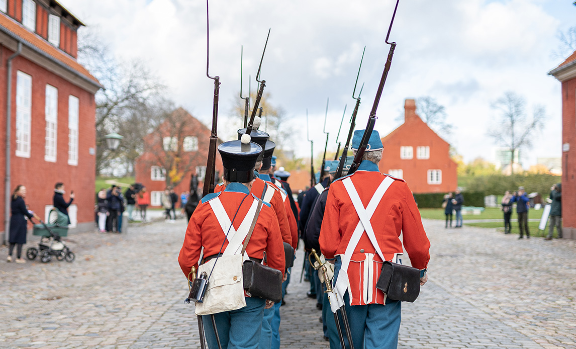 Soldater i gamle uniformer, marchere i Kastellets hovedgade