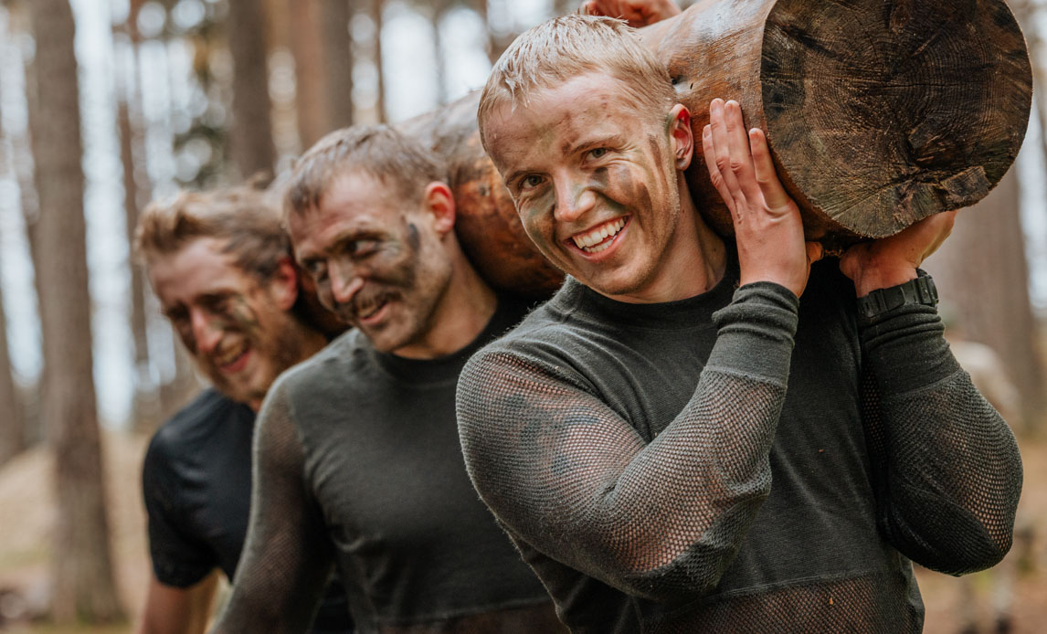 soldater i letland bærer en træstamme