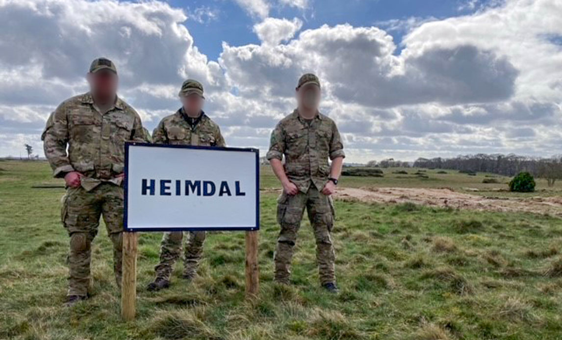 Tre soldater holder skilt med "Heimdal"-tekst på
