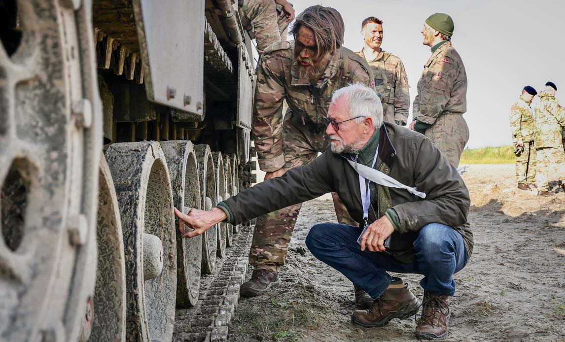 Civil og soldat ser på kampvognens bælter