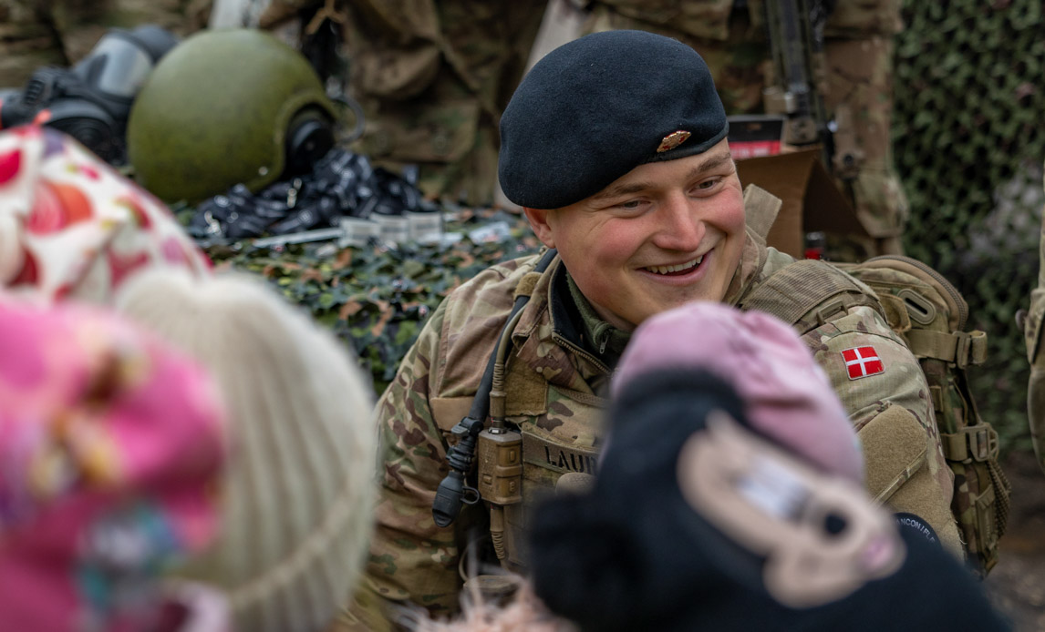 Dansk soldat viser sit udstyr til unge lettere.