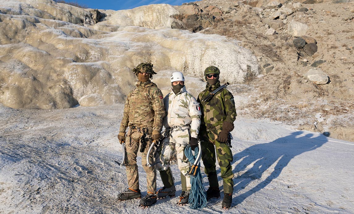 En dansk, en svensk og en fransk soldat ved isklatring i Grønland.
