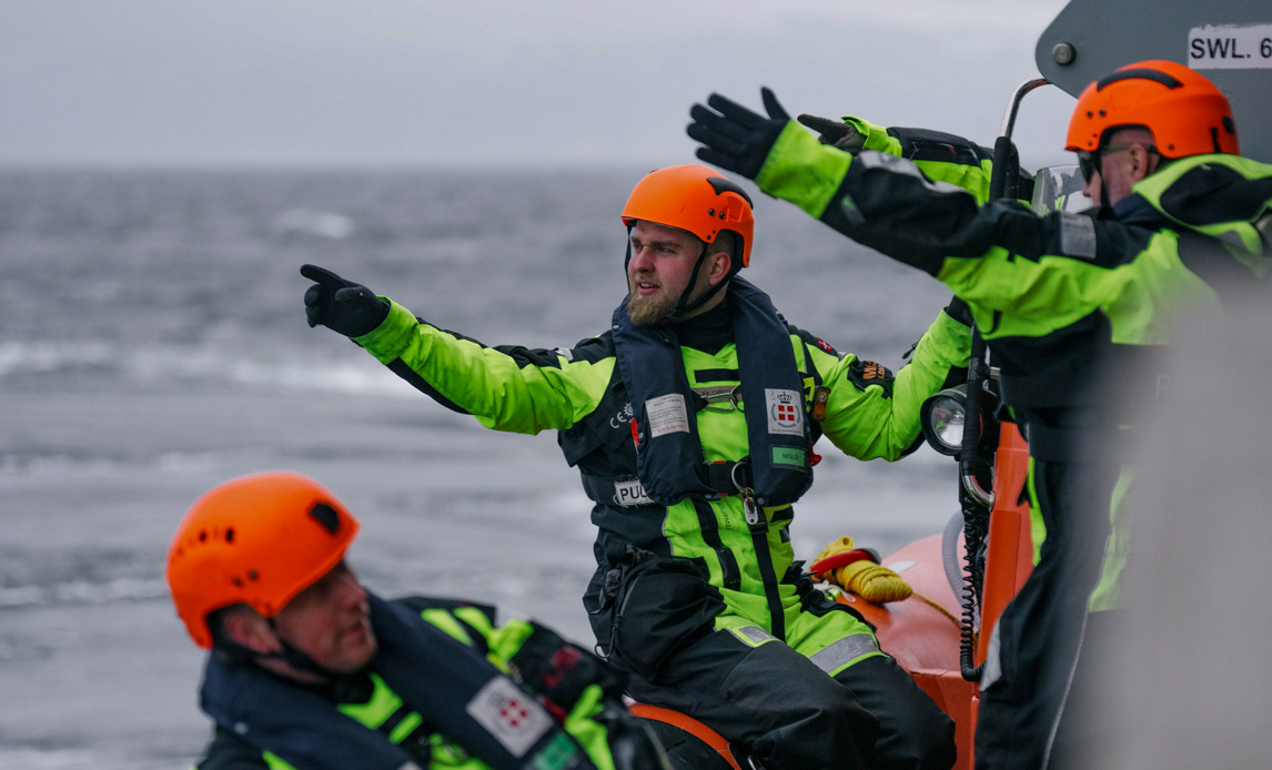 Soldater fra søværnet peger ud over havet