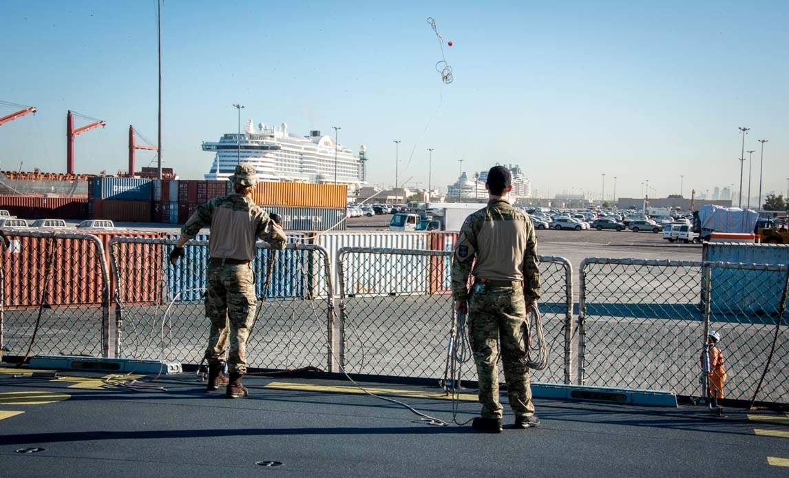 En gast fra Iver Huitfeldt kaster en kasteline ind til personellet på kajen i forbindelse med ankomst til Dubai. Kastelinen benyttes til at trække trosserne op på land, så fregatten kan fortøjes sikkert i havn.