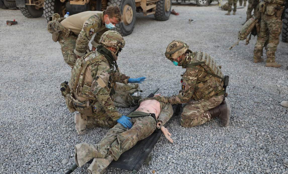 Dansk og britisk soldat yder førstehjælp til tilskadekommen.