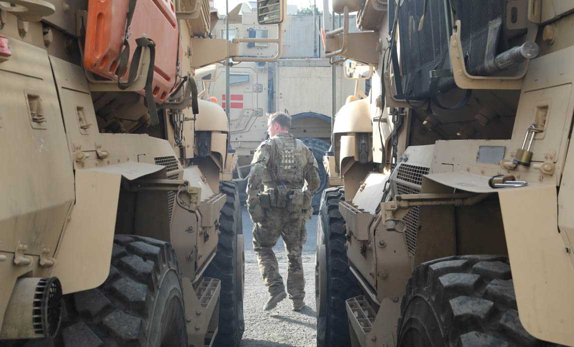 Dansk soldat gør klar til at sidde op på et pansret køretøj under en beredskabsøvelse.