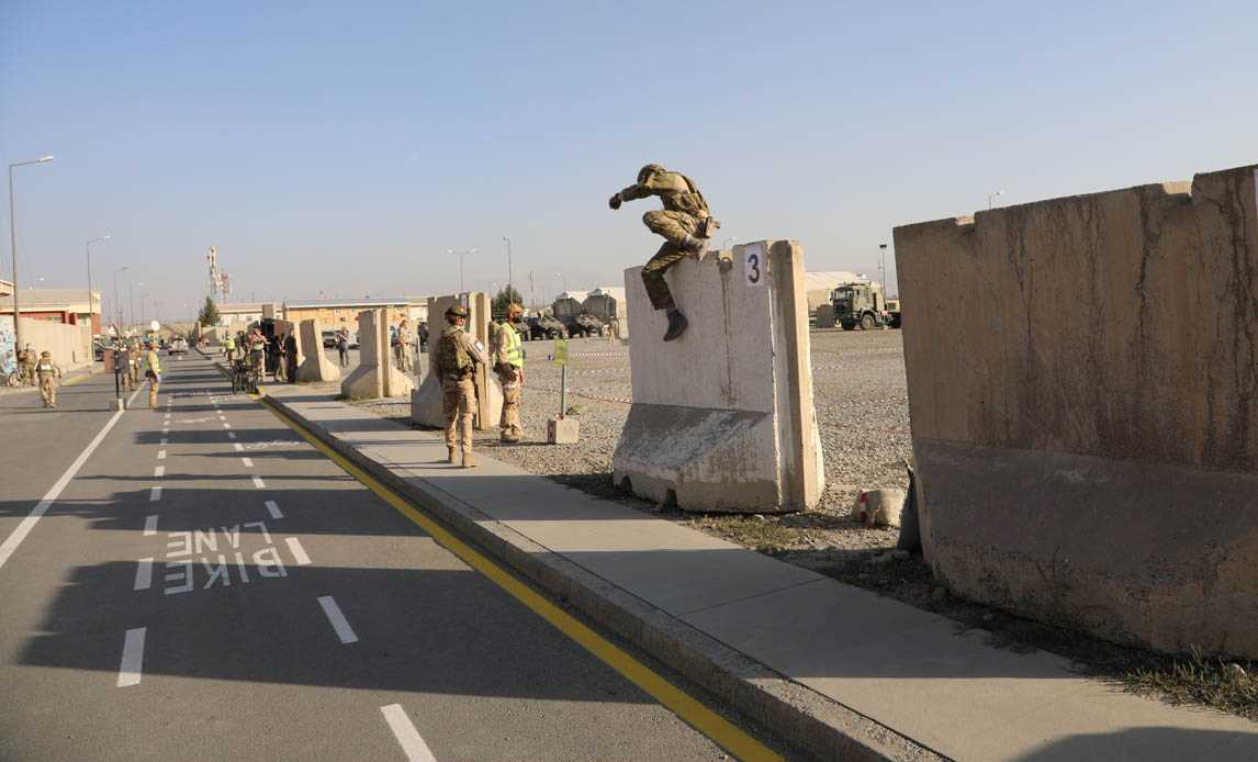 Dansk soldat forcerer en lav T-wall under militærkonkurrence.