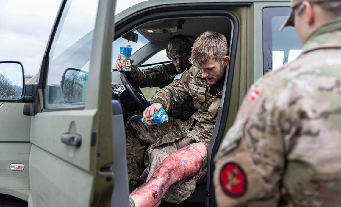 Soldat renser kunstigt sår under øvelsen.