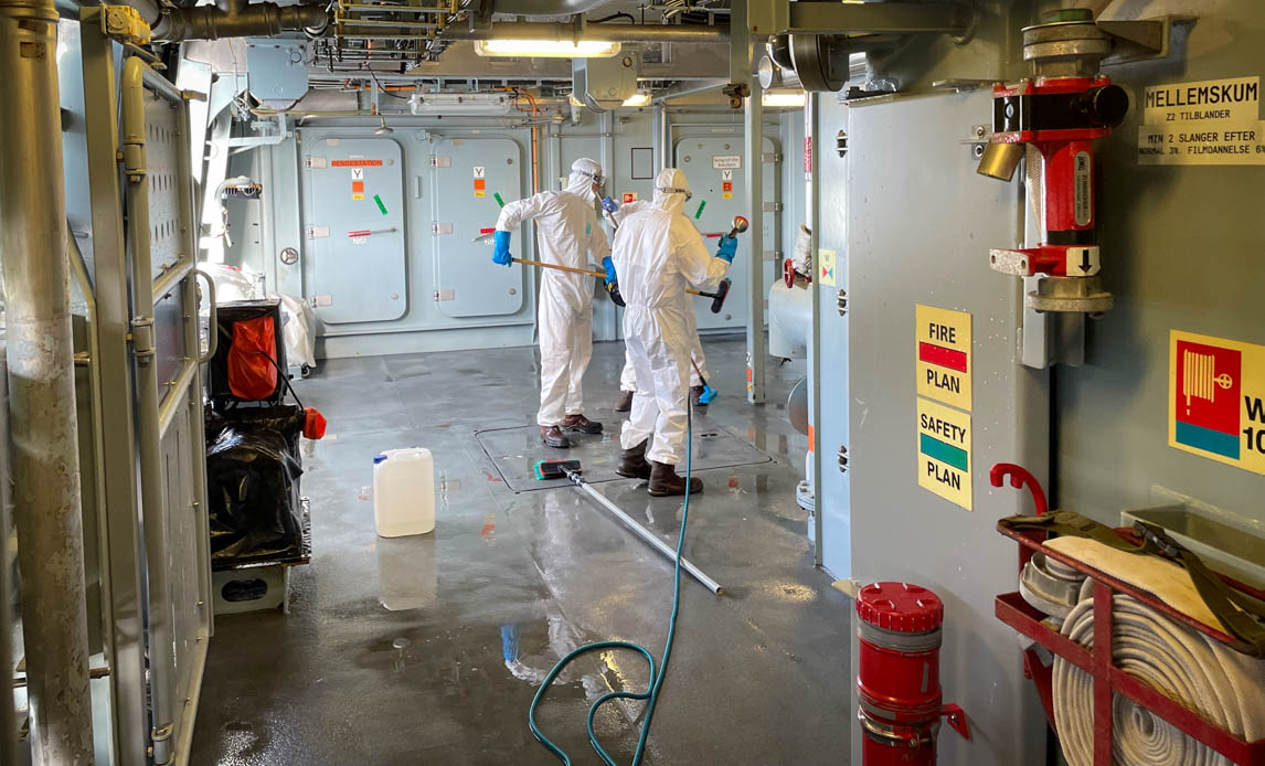 Her ses dele af dæksbesætningen behørigt beskyttet under rengøring af bagbord sidedæk. Foto:
