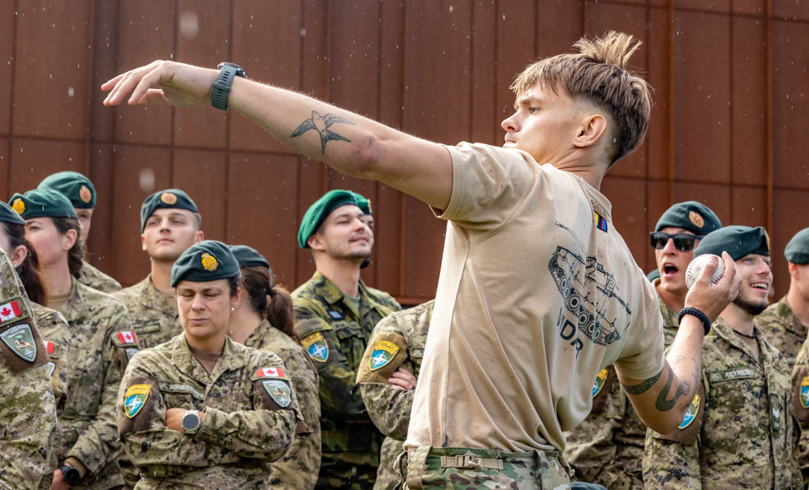 Soldat kaster med håndgranat til idrætsarrangement