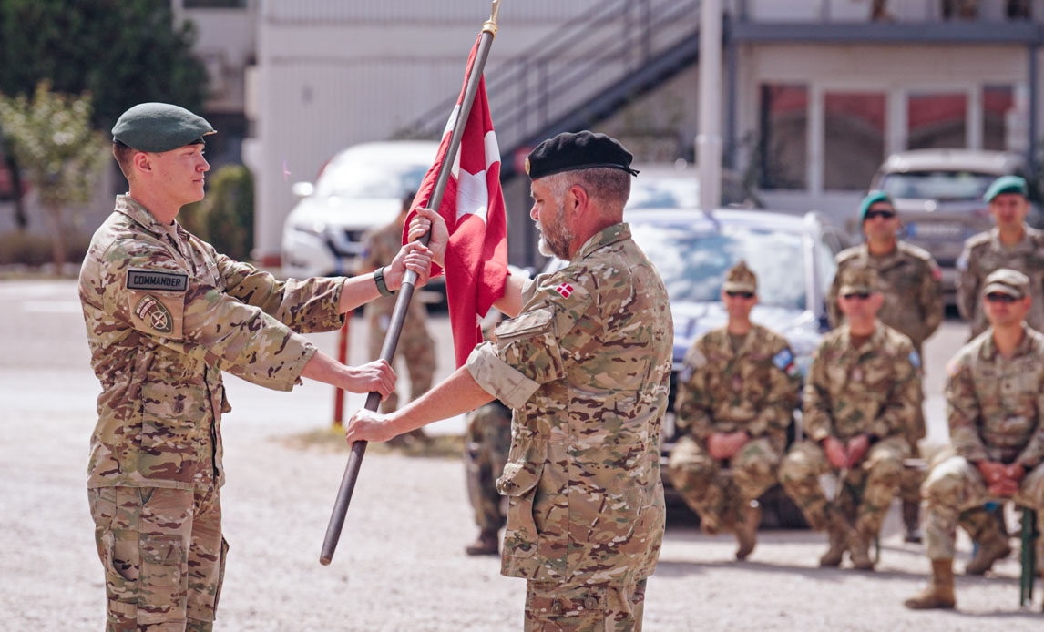 To soldater og et Dannebrog i Kosovo