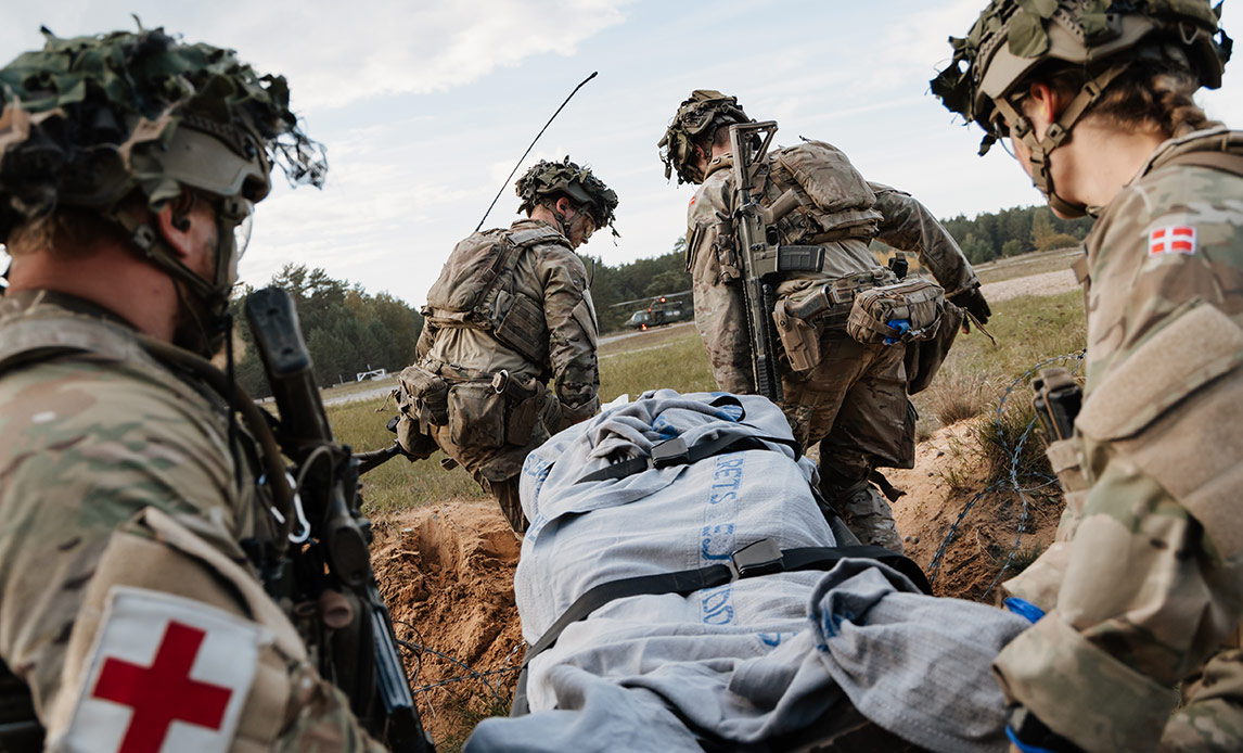 Sanitetssoldater bærer et moment på båre ud til transport i en canadisk Griffon-helikopter.