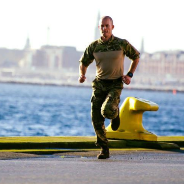 Soldat løber langs havnekanten