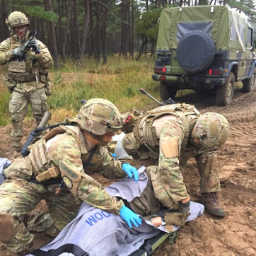 Medics behandler en såret soldat i felten