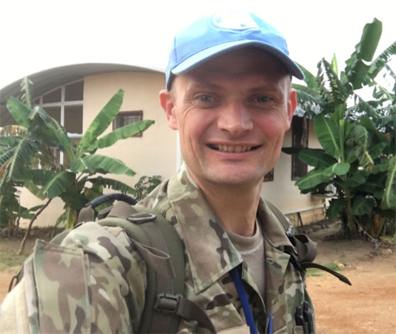 Selfie med en soldat i Sydsudan med palmer i baggrunden